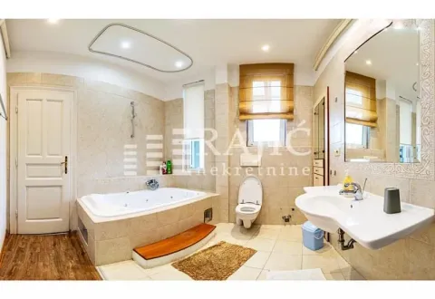 Spacious bathroom equipped with a bathtub, washbasin, and toilet. - image 18