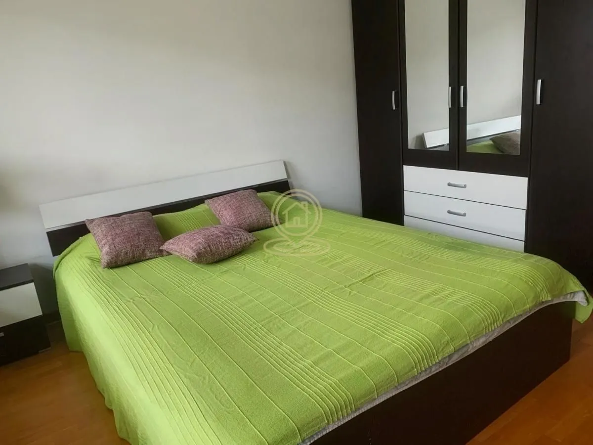 Nameštena spavaća soba sa bračnim krevetom i garderoberom.