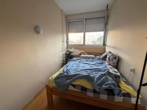 Smaller bedroom with a wooden bed and window. - image 4