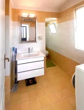 Kupatilo sa umivaonikom, ogledalom i pločicama u krem i bijelim tonovima. - image 7