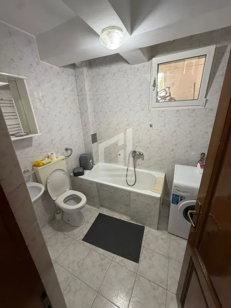 Kupatilo opremljeno kadom, umivaonikom, WC šoljom i veš mašinom.