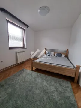 Spavaća soba sa bračnim krevetom, prozorom i parketom na podu. - image 2