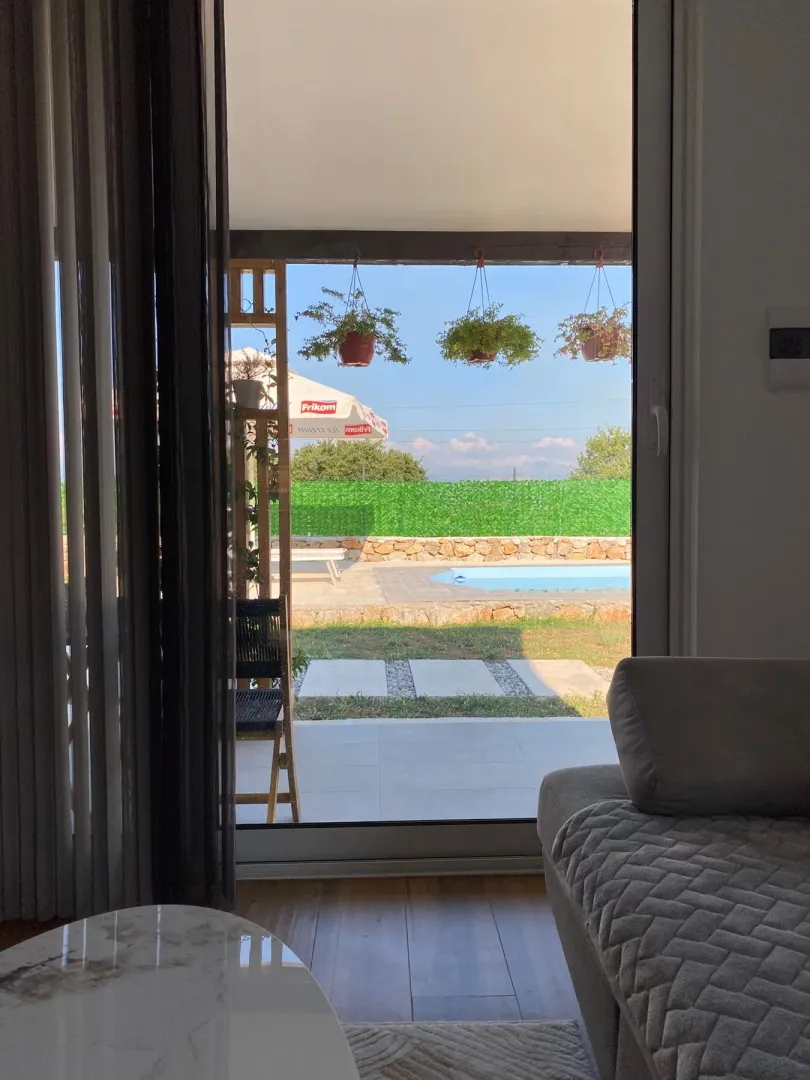 View from the living room to the terrace and courtyard with a swimming pool.