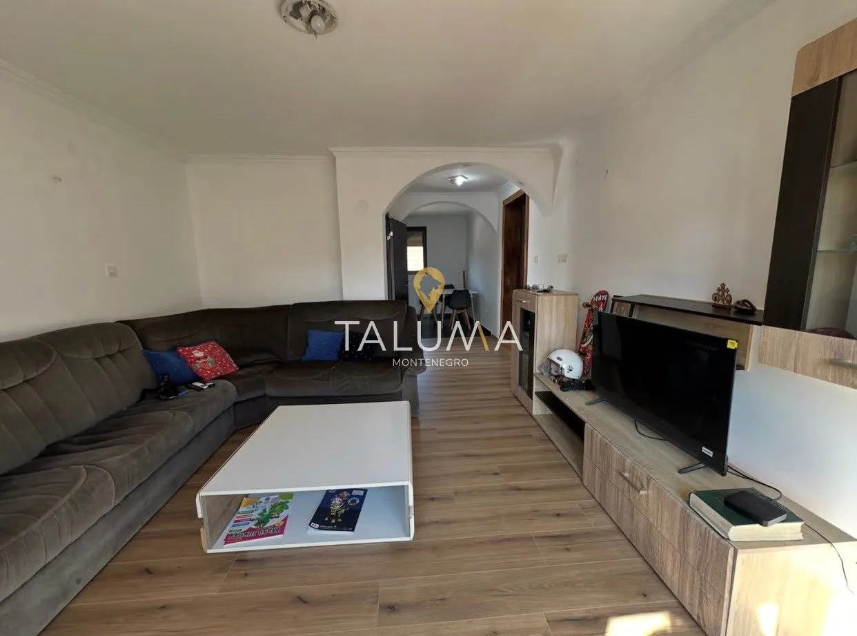 Living room with a corner sofa, television, and coffee table.