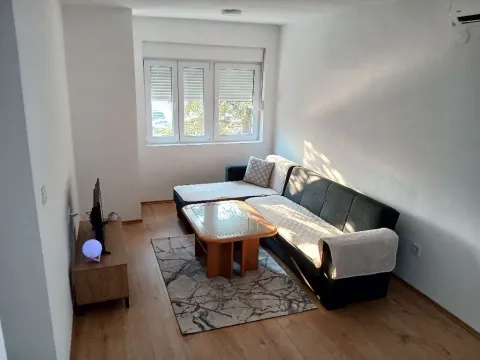 Living room with sofa, coffee table, and television. - image 2