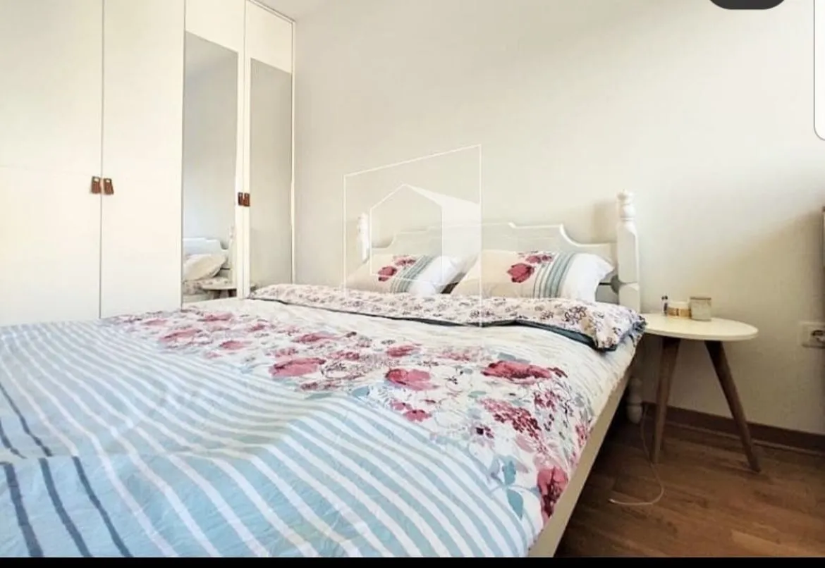Bright bedroom with a double bed and a built-in wardrobe.