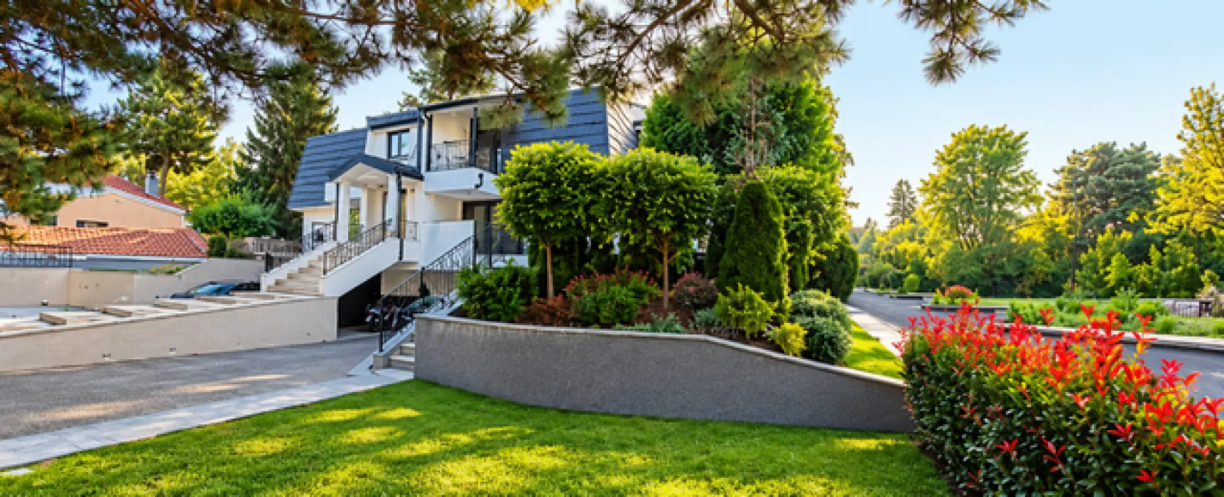 Exterior of a modern house with a landscaped yard and greenery.