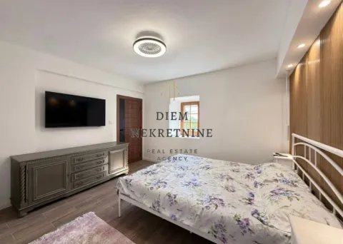 Furnished bedroom with a double bed, dresser, and television. - image 5