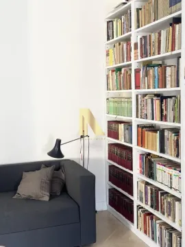 Dnevni boravak sa velikom bibliotekom i tamnom foteljom. - image 15