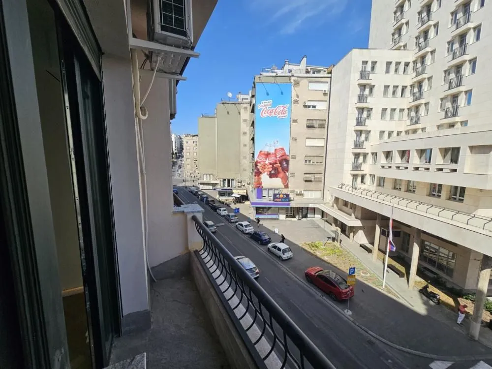 View from the balcony overlooking the city street and surrounding buildings.
