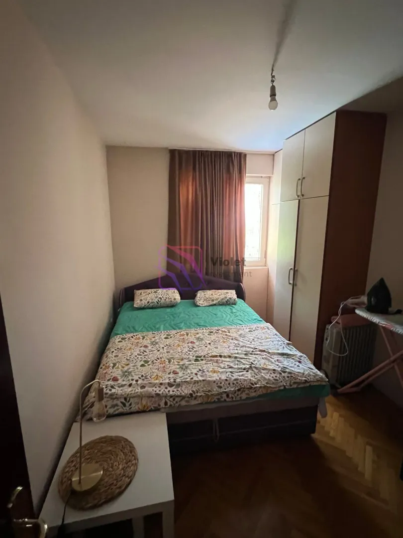 Furnished bedroom with a double bed, wardrobe and window.