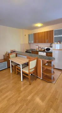 Pregled kuhinje sa trpezarijskim stolom i drvenim elementima. - image 6