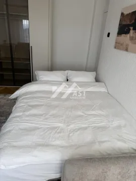 Pogled na bračni krevet sa belom posteljinom u spavaćoj sobi. - image 7