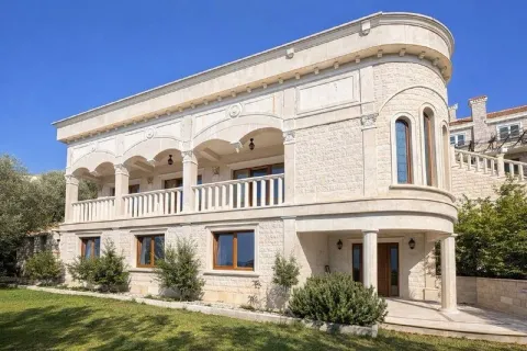 Exterior of a luxury stone house with a balcony and landscaped yard. - image 2