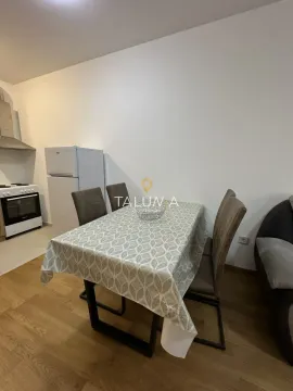Dining table with chairs in the living room with the kitchen in the background. - image 2