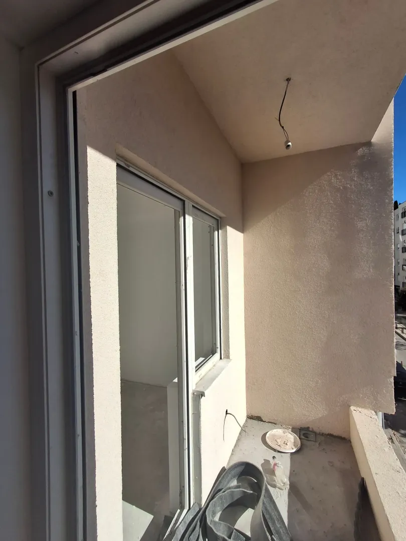 Manji nenamješten balkon sa završnom fasadom i balkonskim vratima.