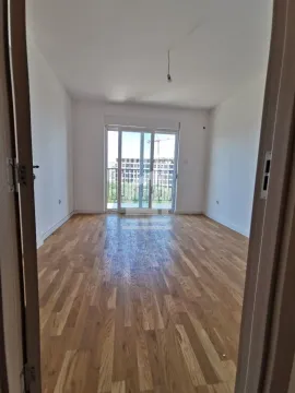 Empty room with wooden flooring and balcony doors. - image 3