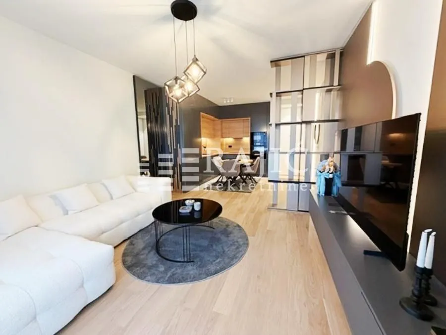 Modern and bright living room with a sofa and dining area in the background.