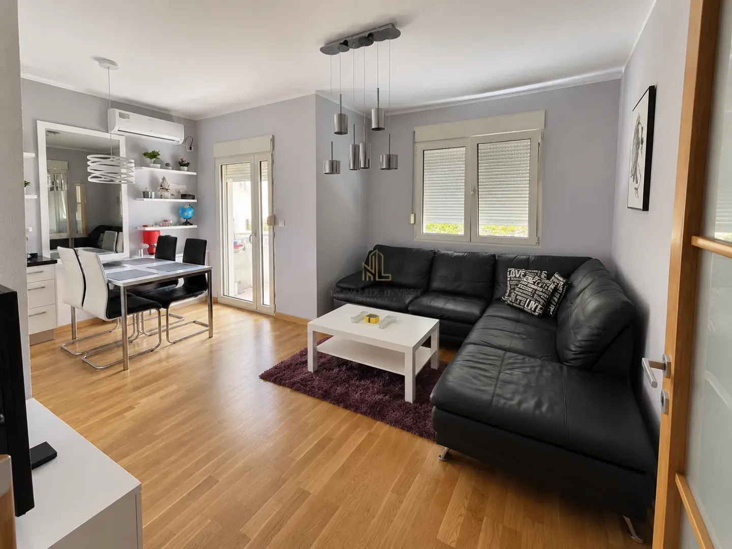 Spacious living room with a corner sofa, dining area, and parquet flooring.