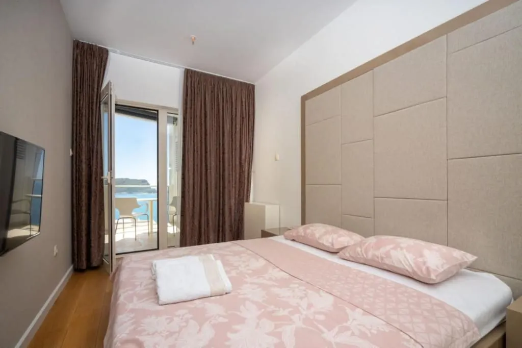 Furnished bedroom with a double bed and access to a terrace with a sea view.