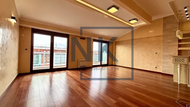 Spacious living room with wooden flooring and access to the terrace.