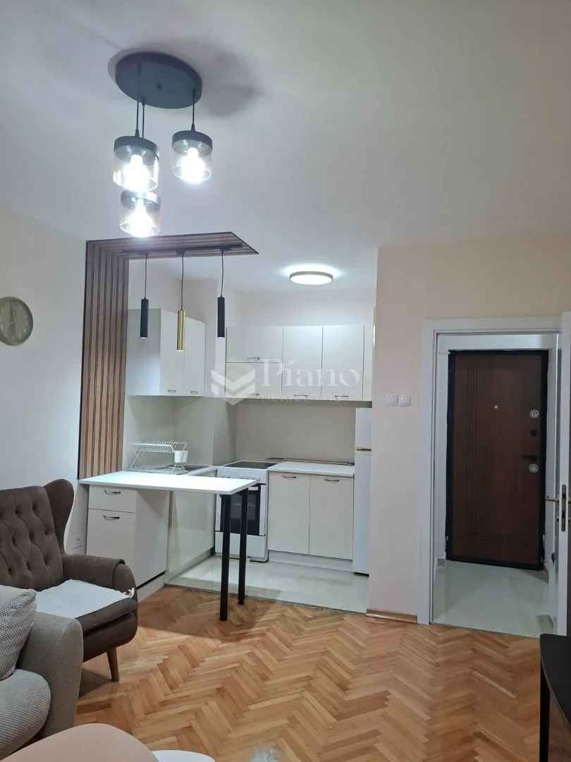 Compact kitchen with white cabinetry and a dining area connected to the living room.