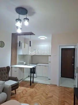 Compact kitchen with white cabinetry and a dining area connected to the living room. - image 2