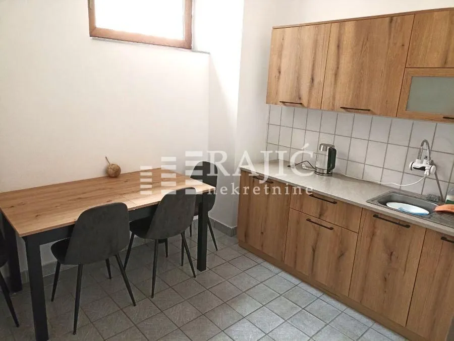 Smaller kitchen with wooden cabinets and a dining table.