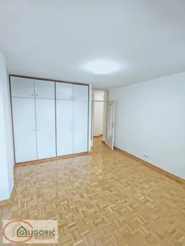 Prazna spavaća soba sa ugradnim ormanom i parketom na podu. - image 13
