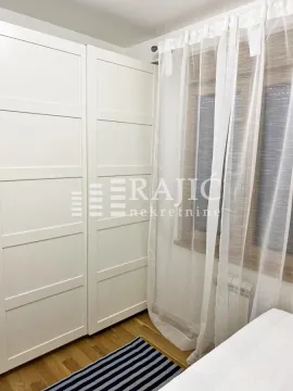 Bedroom with a white wardrobe and a window with curtains. - image 4