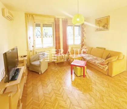 Living room with sofa, television, and parquet flooring. - image 9