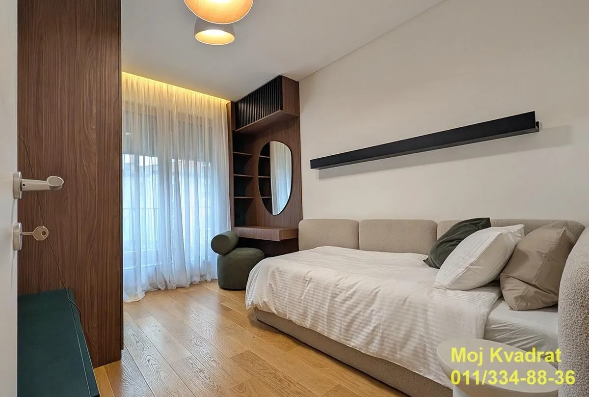 Modern bedroom with a bed, wooden furniture, and built-in wardrobe.