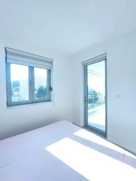Bright bedroom with a bed, window, and terrace access. - image 6
