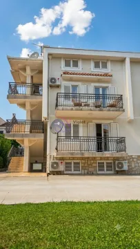 Exterior view of a three-story residential building with balconies and external stairs. - image 4