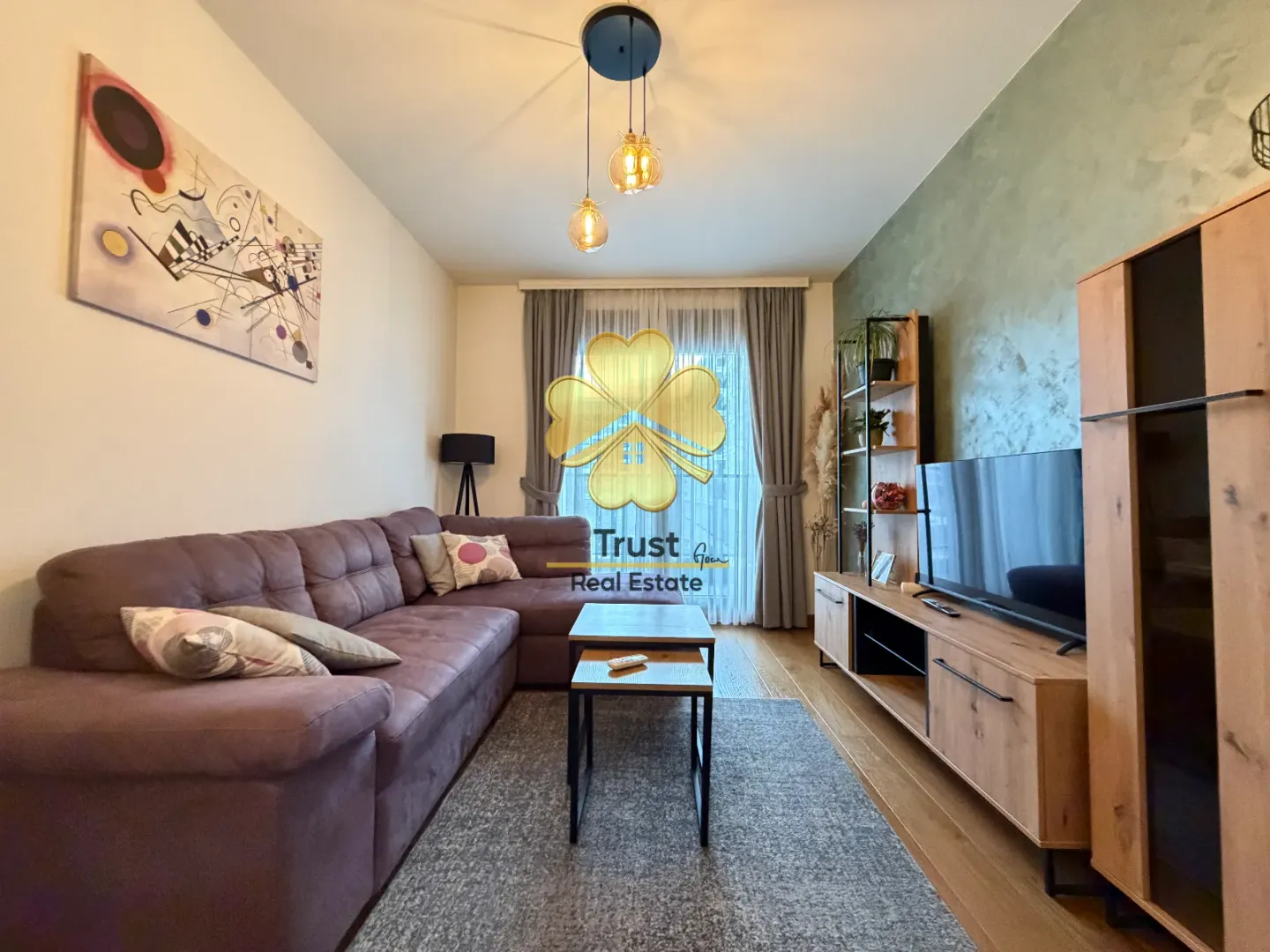 Moderna i uredna dnevna soba sa garniturom i TV komodom.