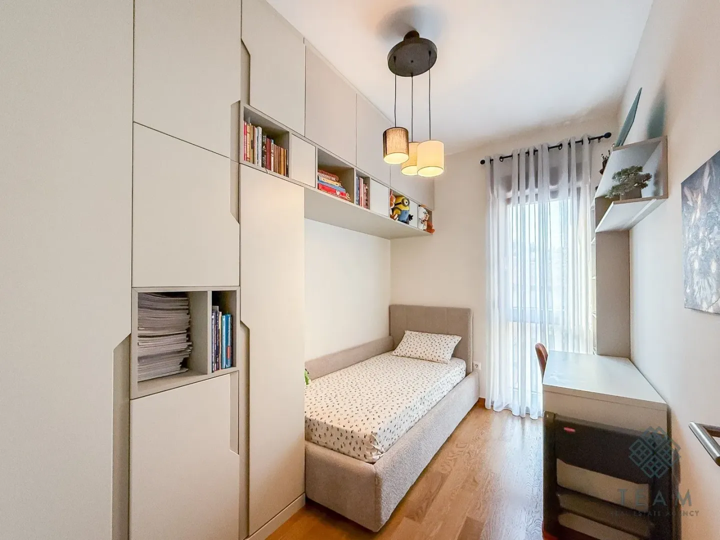 Children's bedroom with a bed, built-in wardrobes, and a desk.