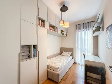 Children's bedroom with a bed, built-in wardrobes, and a desk. - image 8