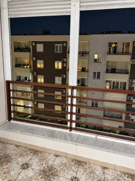View from the glazed balcony overlooking neighboring buildings at night. - image 2