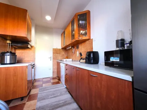 Kuhinja sa drvenim elementima i radnom površinom. - image 6