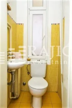 Manje kupatilo sa žutim pločicama, umivaonikom i toalet šoljom. - image 12