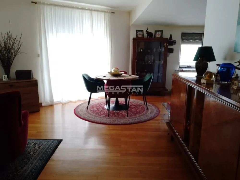 Dnevna soba sa trpezarijskim delom i drvenim nameštajem.