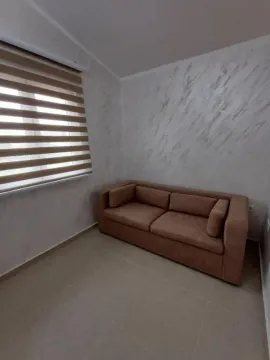 Smaller living room with a sofa and a window with blinds. - image 7