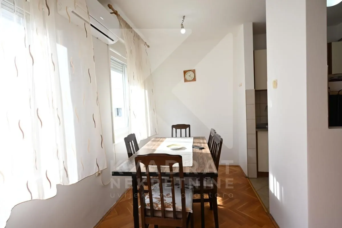Dining area with a wooden table and chairs by the window.