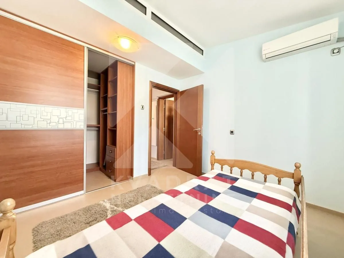 Furnished bedroom with a bed, built-in wardrobe, and air conditioning.