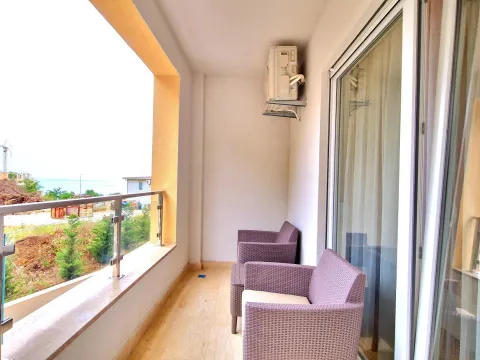 Covered balcony with seating furniture and a view of the surroundings. - image 8