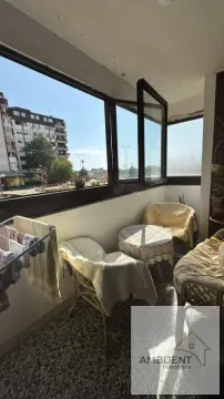 Covered balcony with seating furniture and a view of the surroundings. - image 6