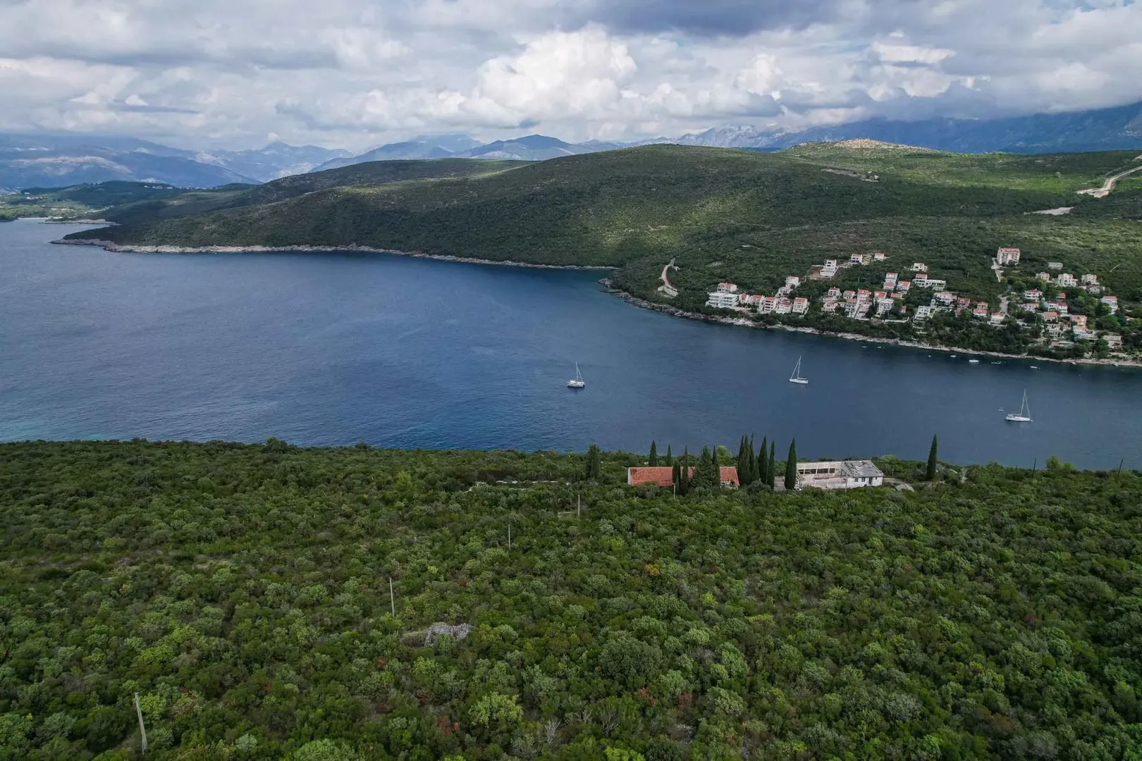 Pogled iz vazduha na more, obalu i brda sa zelenilom.