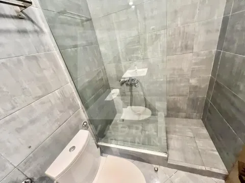 Kupatilo sa tuš kabinom od stakla i sanitarijama u sivim pločicama. - image 9