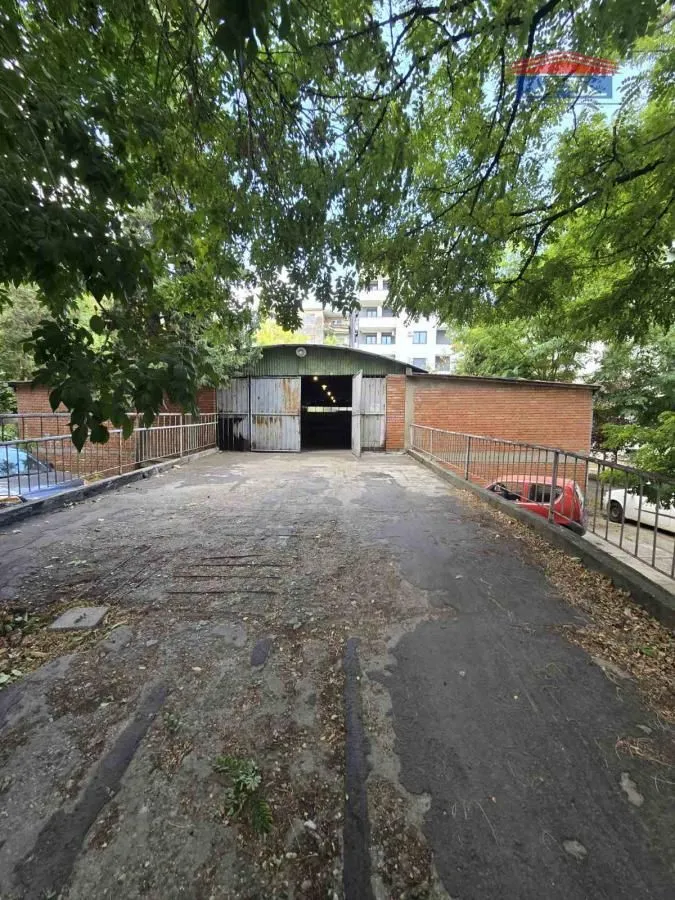 View of the driveway and garage entrance with open metal doors.