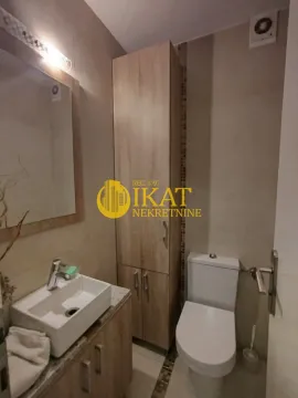 Manje kupatilo sa umivaonikom, WC šoljom i drvenim ormarićem. - image 13